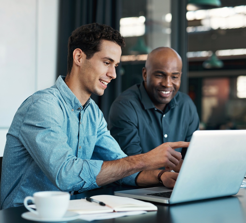 Teamwork, diversity and sales manager planning branding ideas with a creative designer on a laptop in an office. Logo, collaboration and businessman talking to an employee about a development project content-image